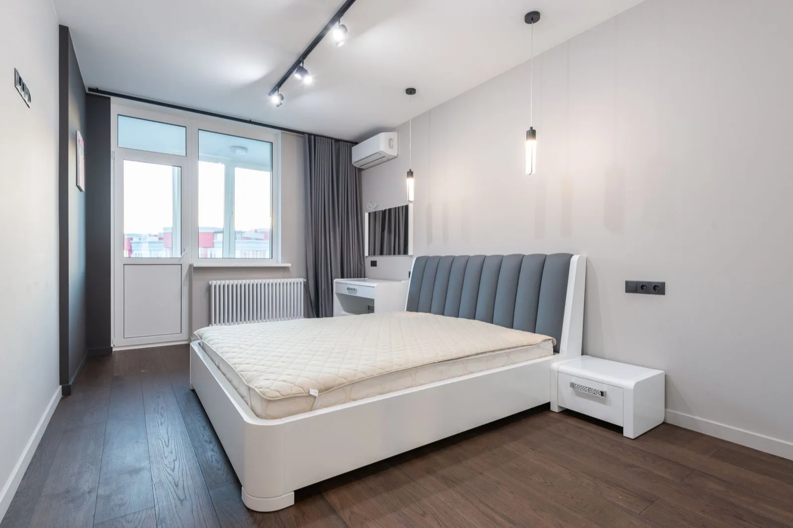 Bedroom with its own mini split indoor unit mounted beside the balcony door