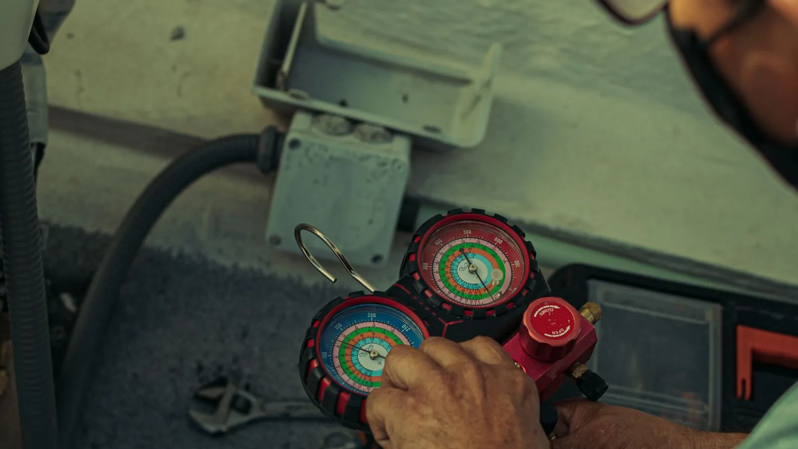 HVAC technician reading a refrigerant manifold gauge set while diagnosing a mini split that is not cooling
