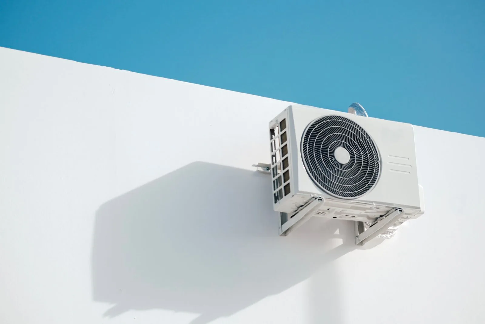 Mini split outdoor unit on a wall bracket with open space around it